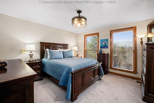 bedroom featuring baseboards and light colored carpet