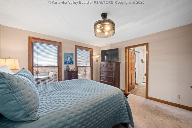 bedroom with light carpet, ensuite bath, and baseboards