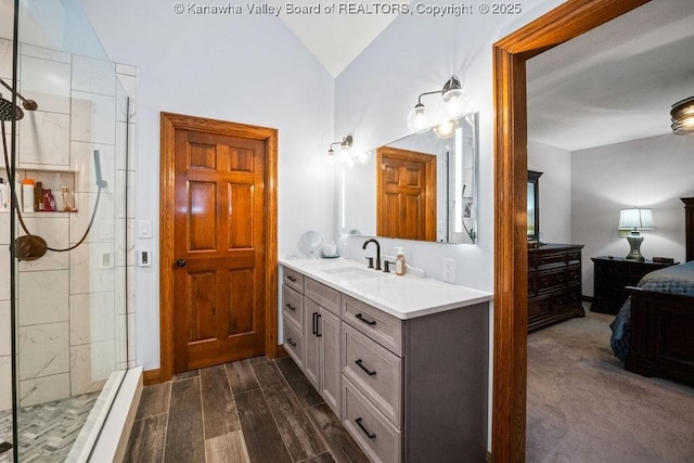 bathroom with lofted ceiling, a shower stall, vanity, and wood tiled floor