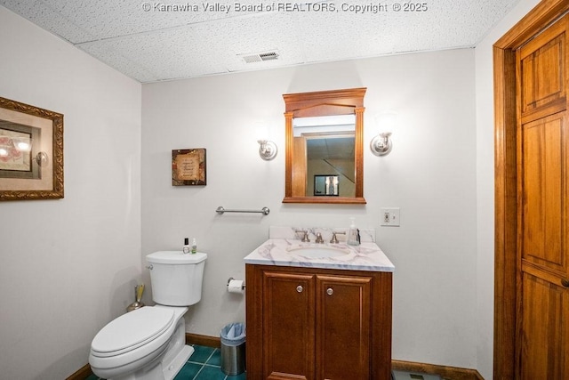 bathroom featuring baseboards, visible vents, toilet, tile patterned floors, and vanity