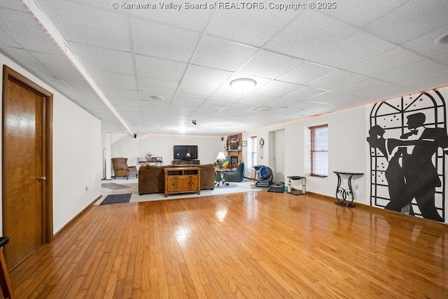 exercise room with a paneled ceiling and wood finished floors