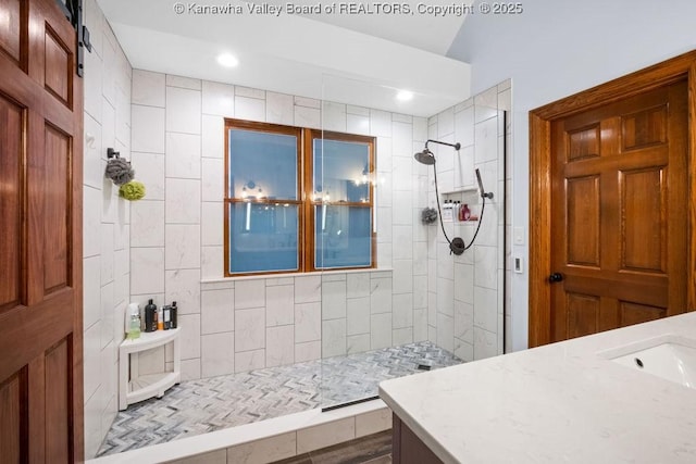 bathroom with walk in shower, a sink, and recessed lighting