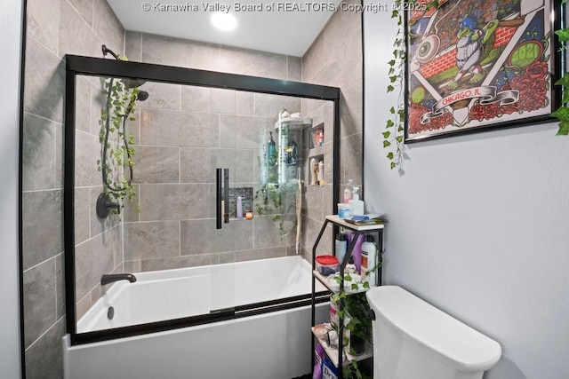 bathroom featuring enclosed tub / shower combo and toilet