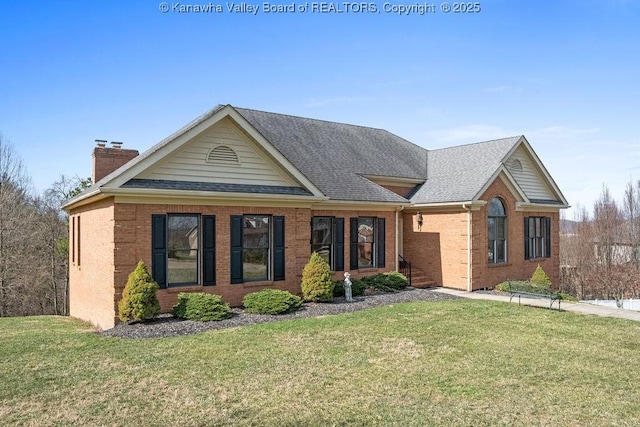 view of front of property featuring brick siding, roof with shingles, and a front yard