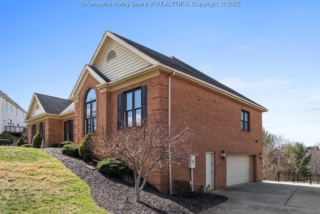 view of home's exterior featuring a garage, a yard, brick siding, and driveway