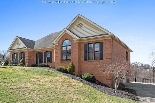 view of front of property with a garage, driveway, brick siding, and a front lawn