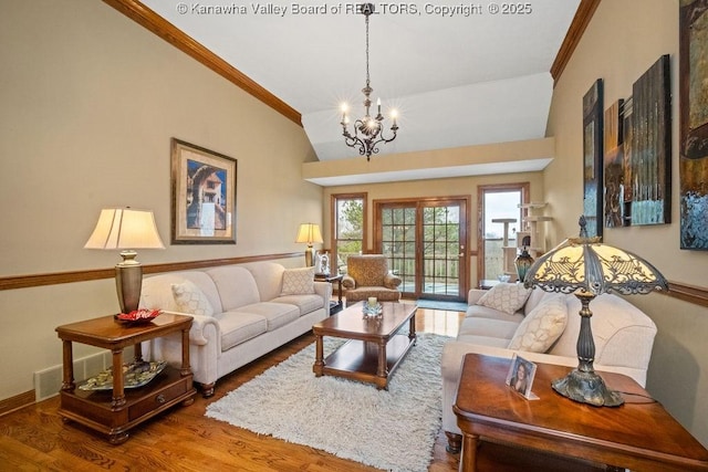 living area with a chandelier, lofted ceiling, crown molding, and wood finished floors