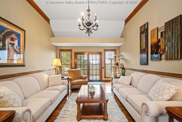 living area with a chandelier, crown molding, and wood finished floors