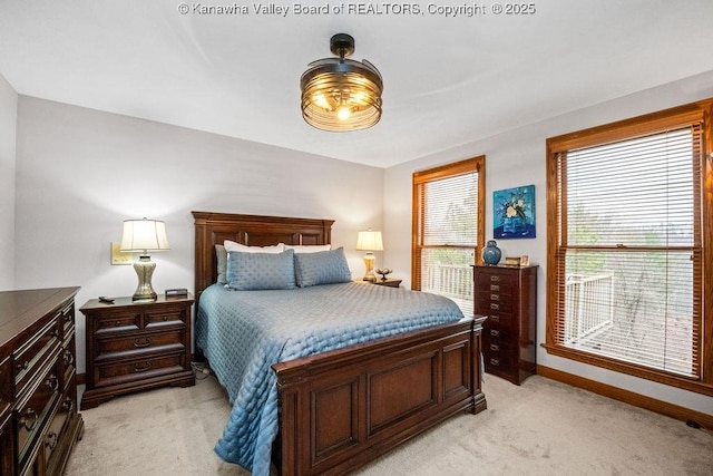 bedroom with light colored carpet and baseboards