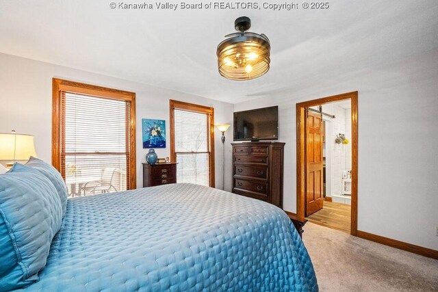 bedroom featuring light carpet, baseboards, and ensuite bathroom