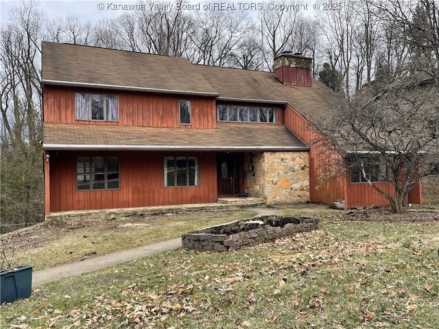 rustic home featuring stone siding and a chimney