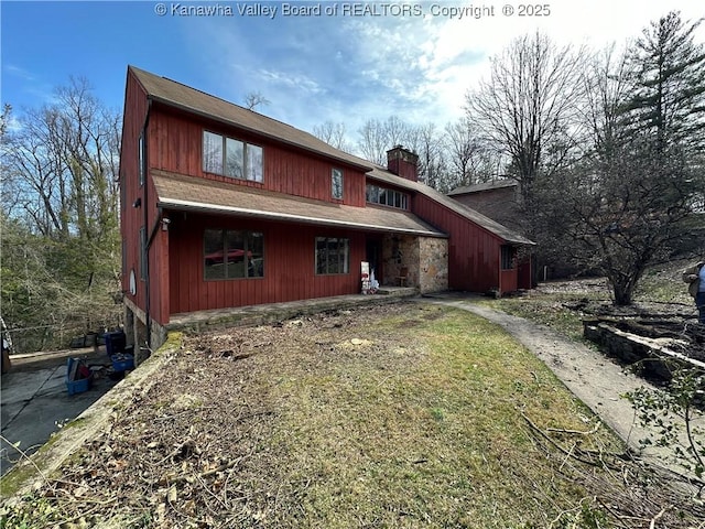 back of house featuring a chimney