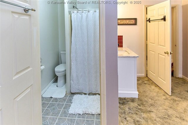 bathroom with curtained shower, vanity, and toilet