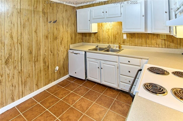 kitchen featuring wooden walls, electric range, white dishwasher, and a sink