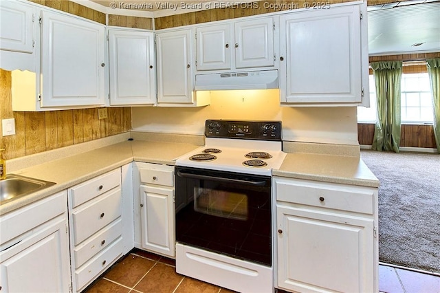 kitchen with under cabinet range hood, white cabinets, light countertops, electric range oven, and dark colored carpet