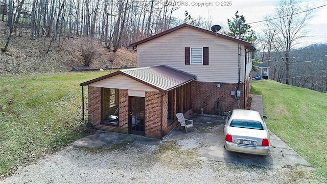 view of property exterior featuring brick siding and a yard