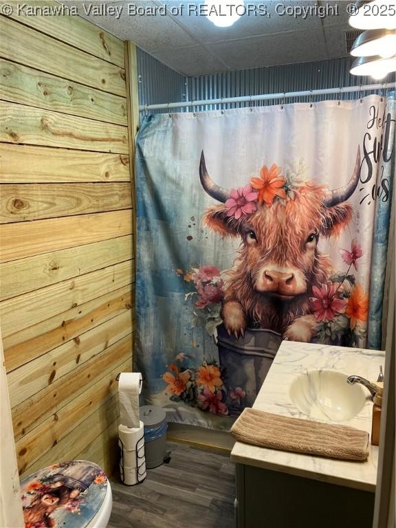 full bath featuring curtained shower, vanity, and wood finished floors