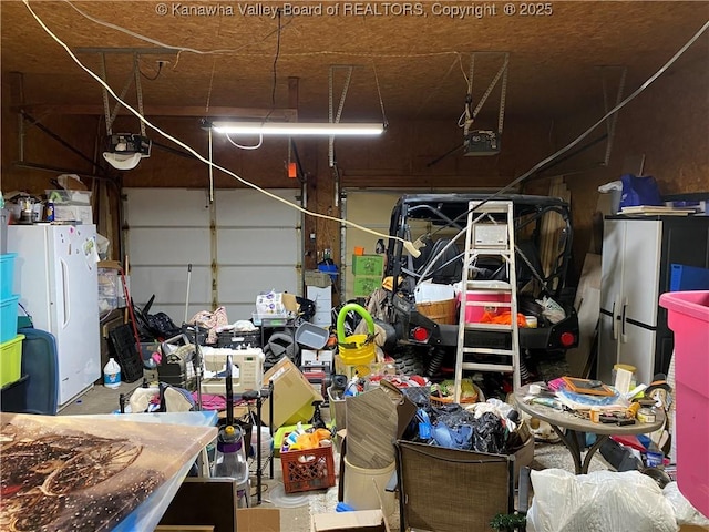 garage featuring a garage door opener and freestanding refrigerator