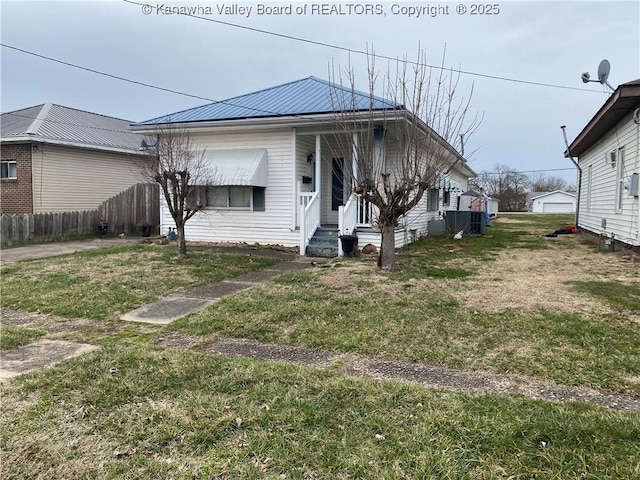 view of front of home with metal roof, a front lawn, and fence