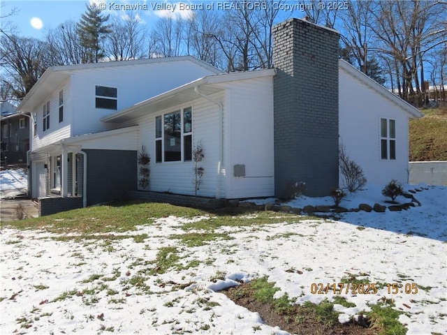 exterior space featuring brick siding and a chimney