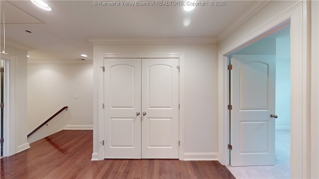 corridor with attic access, ornamental molding, wood finished floors, and an upstairs landing