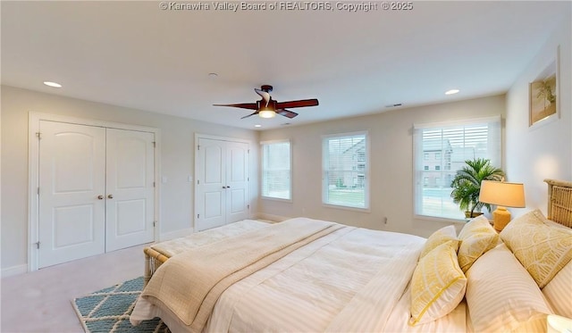 bedroom featuring baseboards, carpet flooring, multiple closets, and recessed lighting