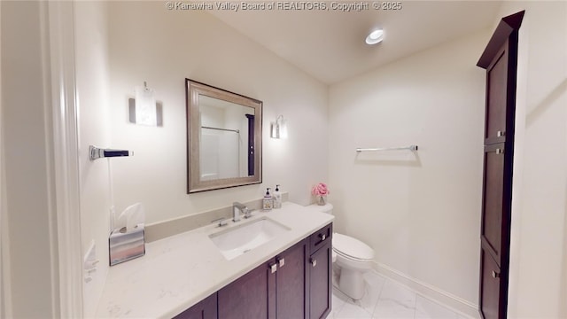 bathroom with marble finish floor, vanity, toilet, and baseboards