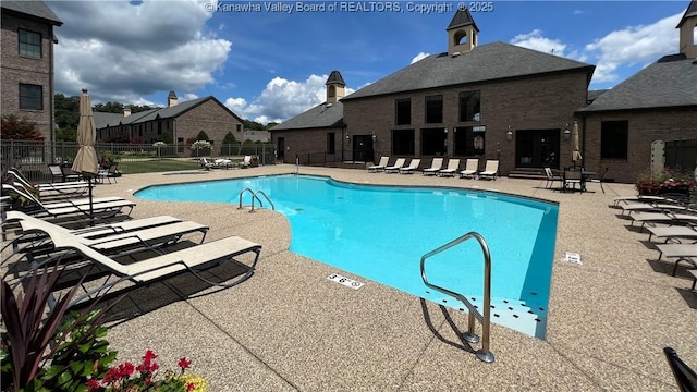 community pool featuring fence and a patio