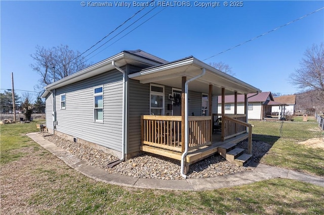 view of front of home featuring fence and a front lawn