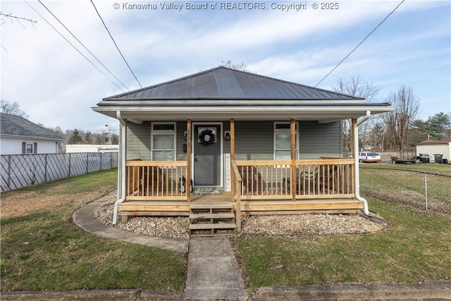 view of front facade featuring metal roof, a porch, a front lawn, and fence