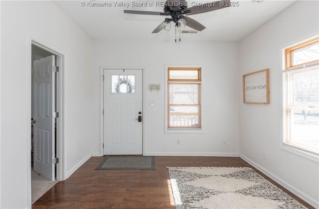 foyer entrance featuring dark wood-style floors, ceiling fan, visible vents, and baseboards