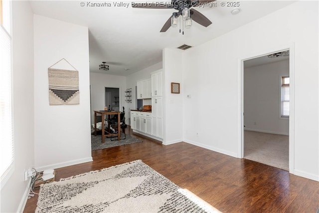 interior space featuring visible vents, dark wood finished floors, and baseboards