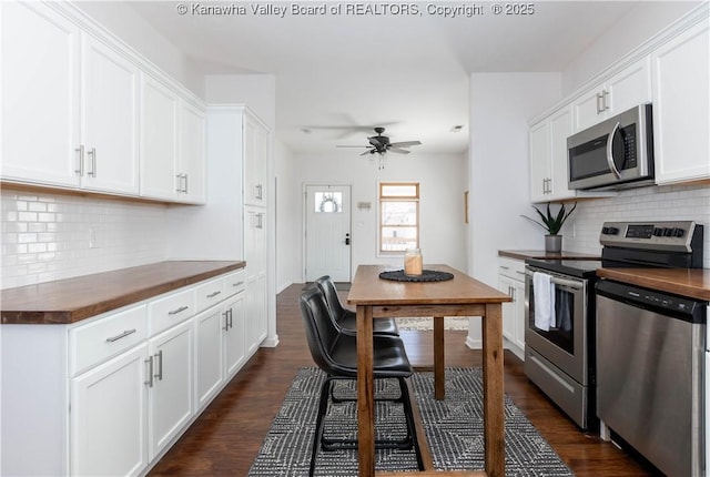 kitchen with dark countertops, white cabinetry, appliances with stainless steel finishes, and dark wood finished floors