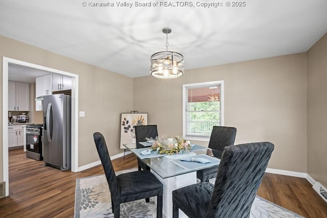 dining space with baseboards, dark wood-style flooring, and a chandelier