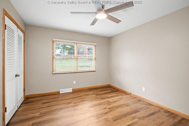 unfurnished bedroom featuring light wood finished floors, visible vents, baseboards, a closet, and a ceiling fan