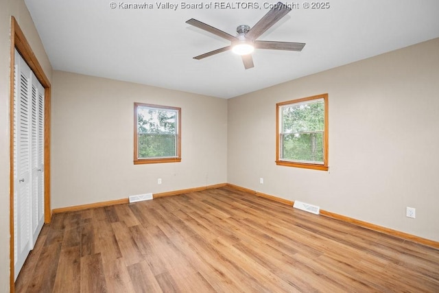 unfurnished bedroom with baseboards, visible vents, a closet, and light wood-type flooring