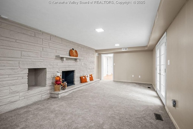 unfurnished living room featuring a fireplace, visible vents, and carpet floors