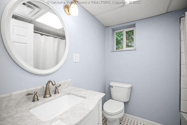 full bathroom with toilet, vanity, and baseboards