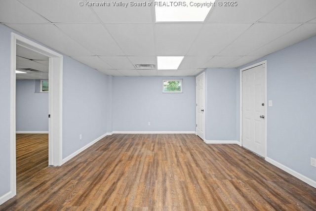 below grade area with visible vents, wood finished floors, and baseboards