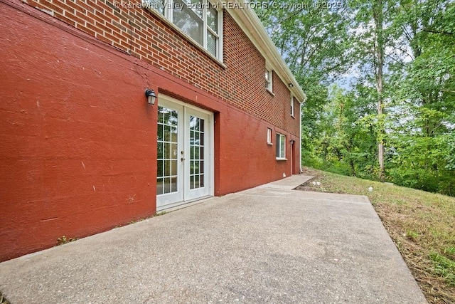 view of home's exterior with brick siding, french doors, and a patio