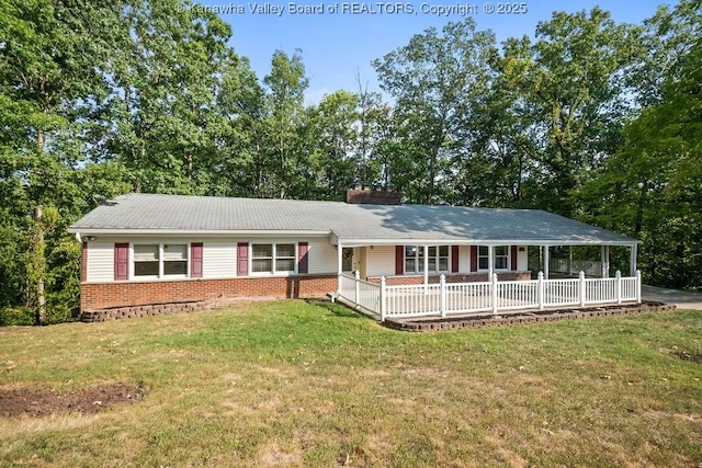 ranch-style home featuring brick siding, a porch, a chimney, and a front yard