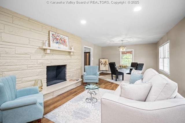 living room featuring a fireplace, recessed lighting, and wood finished floors