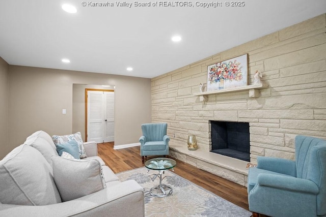 living area featuring recessed lighting, baseboards, wood finished floors, and a fireplace