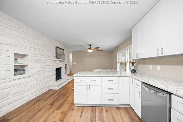 kitchen with dishwasher, a peninsula, open floor plan, and white cabinetry