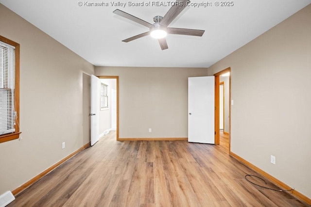 unfurnished bedroom with light wood-type flooring, baseboards, multiple windows, and ceiling fan