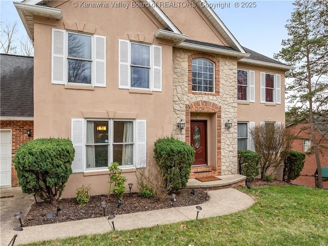 view of front of house with a shingled roof, stone siding, and stucco siding