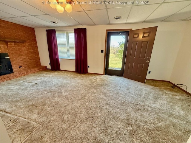 unfurnished living room with carpet flooring, a healthy amount of sunlight, visible vents, and a drop ceiling