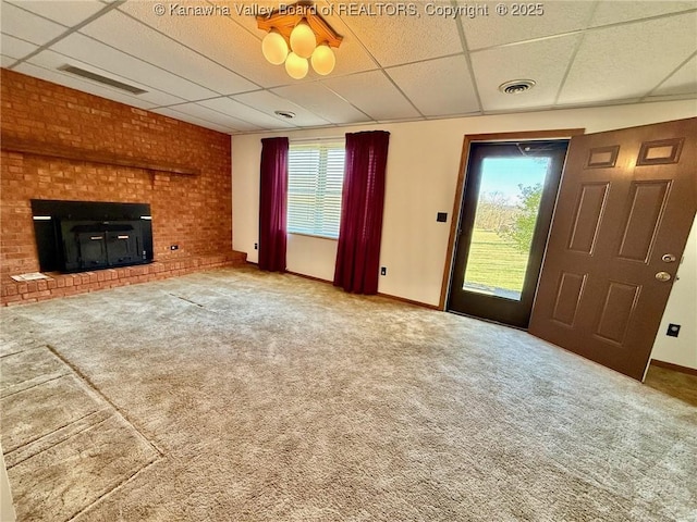 unfurnished living room with carpet flooring, a paneled ceiling, and visible vents