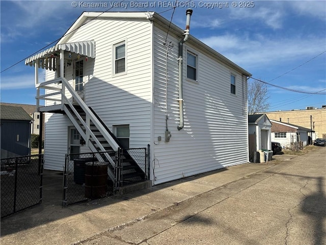 rear view of property featuring stairway, central air condition unit, and fence