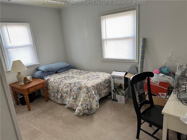 bedroom featuring ornamental molding, multiple windows, and light carpet